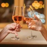 two_people_clinking_glasses_of_orange_wine_seville