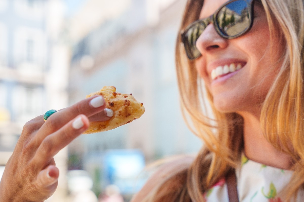 Guest eating a cheese bread outside.